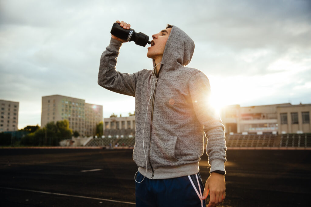 the sportsman is drinking a water after working out the sportsman is drinking a water after working out